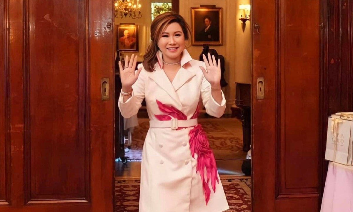 Olivia Quido waving to people walking in to Beauty Day event