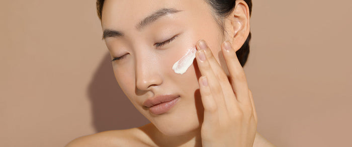 Model applying Olivia Quido Skincare's Broad Spectrum Sunscreen SPF 50