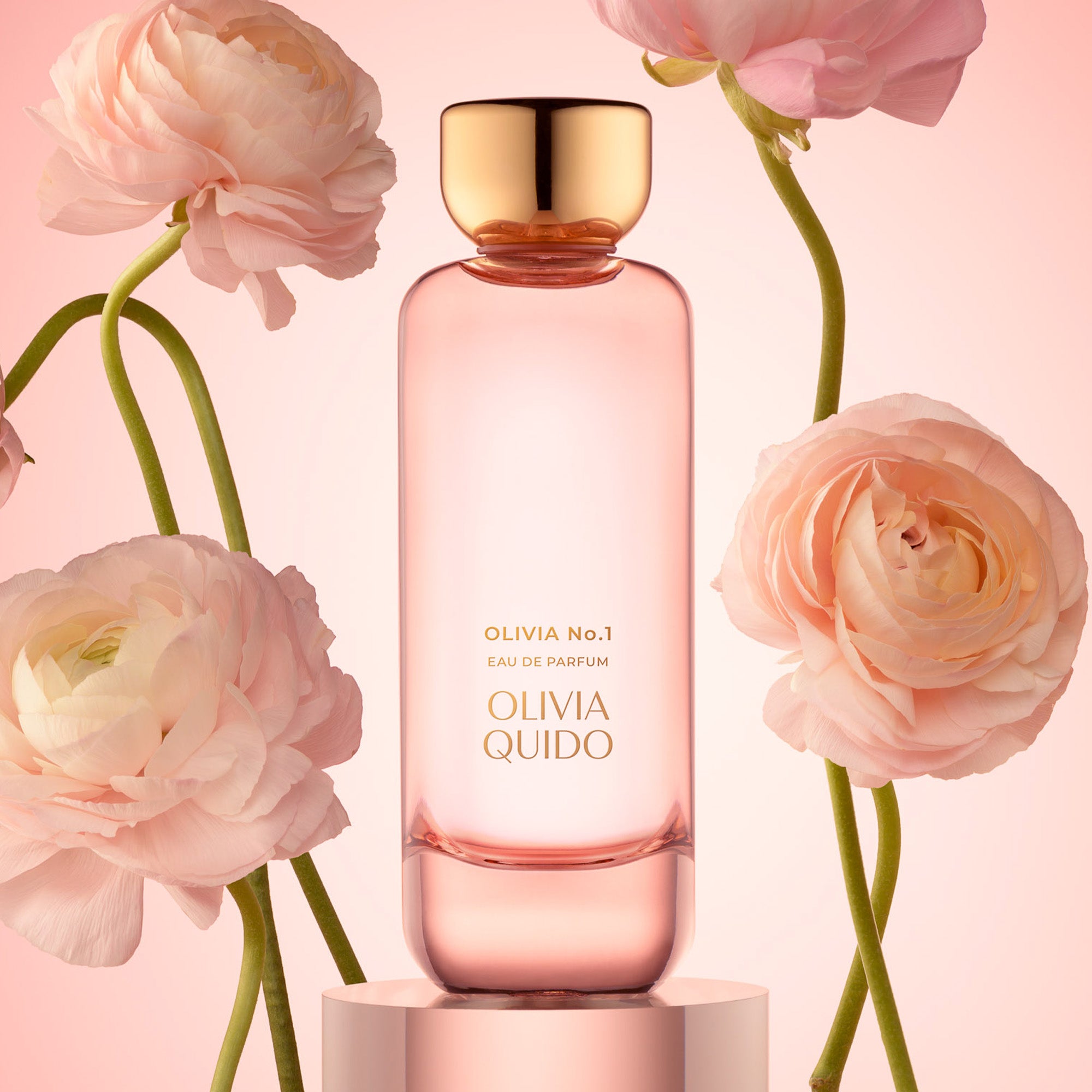 Olivia Quido Olivia No.1 Eau de Parfum bottle surrounded by pink flowers on a pastel background.