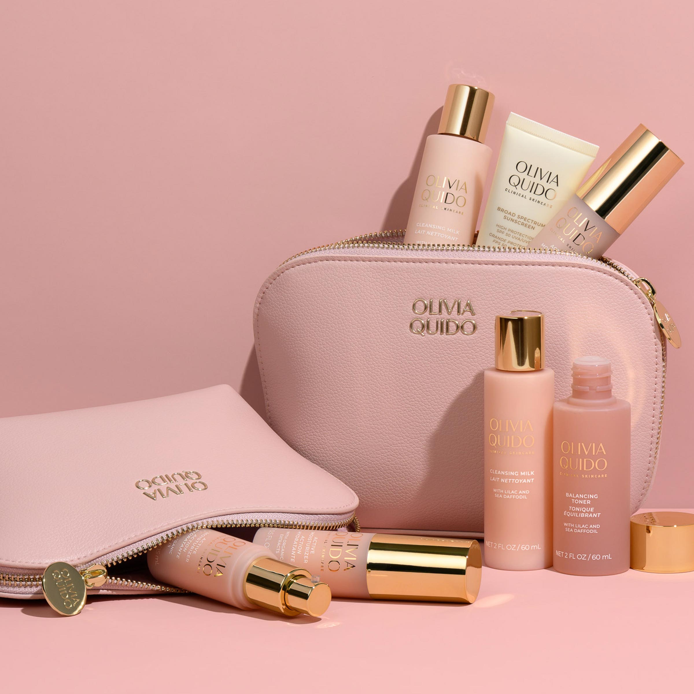 Olivia Quido Faux Leather Dome Cosmetic Bag with skincare products arranged on a pink background.