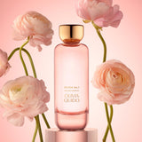 Olivia No.1 Eau de Parfum bottle surrounded by pink ranunculus flowers on a pastel background.