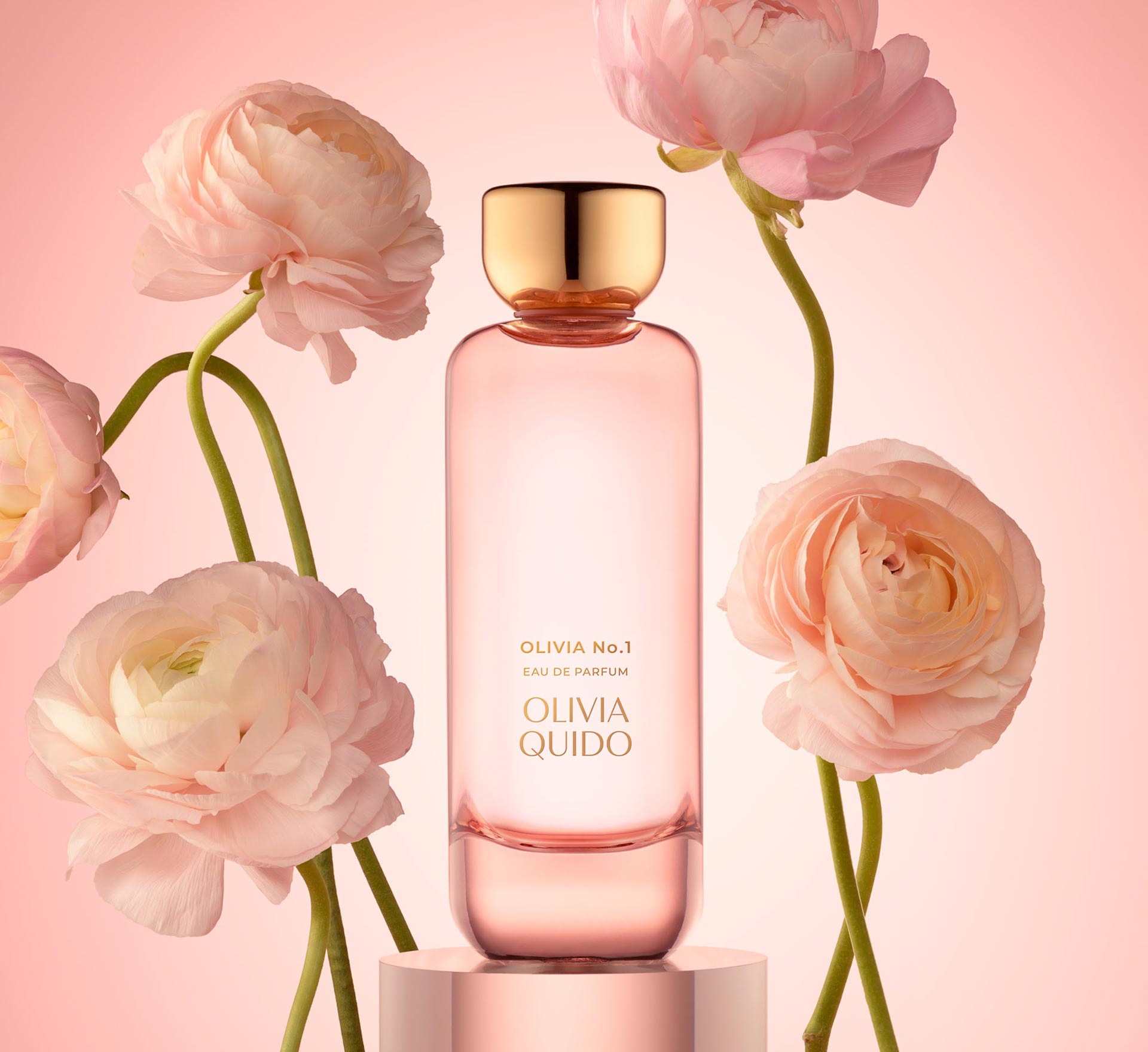 Olivia No.1 Eau de Parfum bottle surrounded by pink ranunculus flowers on a pastel background.